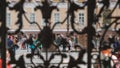 View on a tourists walk on the Palace Square across a wrought-iron grating of the gate o