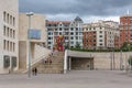 View of tourists walking in downtown Bilbao, square with modern staircase, classic buildings in tourist area