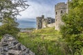 A view towards the Carew estuary between a dry stone wall and the ruins of Carew Castle, Pembrokeshire, UK Royalty Free Stock Photo