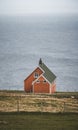 View towards orange house on Akraberg lighthouse at Suduroy island at summer, Faroe Islands. Royalty Free Stock Photo