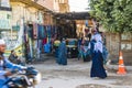 View towards the souk of Esna in Egypt on the way to the Chnum temple. People in traditional clothes in the middle of cars, mopeds