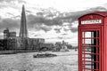 View from Tower Bridge against Thames river with tourist boat and red phone booth in London, England, UK Royalty Free Stock Photo