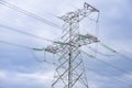 Electricity pylon or tower with its cables carrying high voltages against the of blue sky and clouds Royalty Free Stock Photo