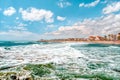 View on the town and the beach from sea with big waves, Sitges, Spain Royalty Free Stock Photo