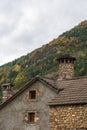 View of traditional architecture with chimney, with autumn forest, in Torla, Huesca, Spain