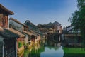 Traditional Chinese houses and bridge by water under blue sky, in the old town of Wuzhen, China