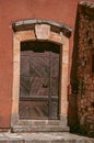 View of traditional colorful house in ocher and wooden door, in Roussillon.