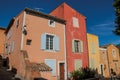 View of traditional colorful houses in ocher under a sunny blue sky, in the Roussillon. Royalty Free Stock Photo