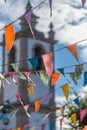 View of traditional decoration of religious festivals on the villages, with colored triangles of paper hanging in threads, church Royalty Free Stock Photo