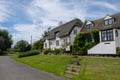 View of a traditional English cottage and thatched roof with a well painted lawn area. Royalty Free Stock Photo