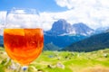 View of the traditional Italian alcoholic drink Aperol Spritz on the background of colorful Italian meadows and the