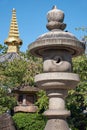 Traditional stone lanterns with pagoda sorin on the background in the temple garden. Osaka. Japan Royalty Free Stock Photo