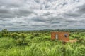 View of traditional terracotta house isolated on the middle at the tropical landscape, cloudy sky as background