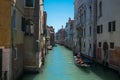 View of traditional venetian gondola boat in water canal with couple of lovers taking a romantic and relaxing ride during a sunny