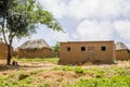 View of traditional village, thatched and zinc sheet on roof houses and terracotta brick walls, cloudy sky as background, in Royalty Free Stock Photo