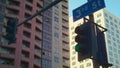 View traffic lights with blue sign number street on high buildings background.