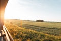 View from the train window in the motion of the countryside and the blue sky on a bright sunny warm summer day at sunset. Royalty Free Stock Photo