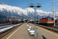 View of trains parking by the platforms of the Main Station in Innsbruck on a sunny winter day and snowy Nordkette mountain Royalty Free Stock Photo