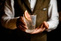 view of transparent glass with freshness drink in hands of male bartender