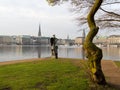 View at tree and sculpture named Windsbraut, whirlwind and Binnenalster and Jungfernstieg in Hamburg, Germany.