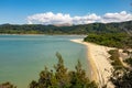 A view through the trees of an inlet and beach at the incredibly beautiful Able Tasman National Park, South Island, New Zealand