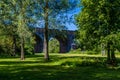 A view through trees towards the fourteen arches viaduct at Wolverton, UK