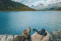 View trekking feet tourist backpack photo camera on background panoramic landscape mountain in Norway
