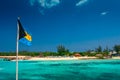 View on the tropical island in Bahamas with the national Bahama flag. Royalty Free Stock Photo