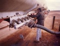 View of truck driver working with pipe to transfer petroluem