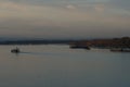 View on tug boats, barges and pushers from container terminal on the Columbia river surrounded by trees and bushes during sunset Royalty Free Stock Photo