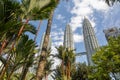 View of the Twin Towers through the palm trees of KLCC Park. Urban oasis with water fountain show