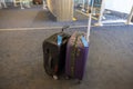 View of two carry-on suitcases standing on airport floor, with special tags on handles intended as hand luggage.