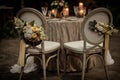 View of two chairs decorated with flowers placed against table with glowing candles