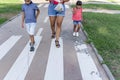 Two kids walking with their mother outdoors in a pathway in a park. Royalty Free Stock Photo