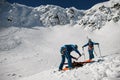 view of two men skiers in ski suits and helmets putting on hiking equipment for climbing Royalty Free Stock Photo