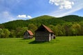 View of two old wooden houses in the field on a cloudy day background Royalty Free Stock Photo