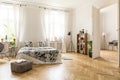 View at two rooms with white walls and herringbone parquet. A be