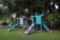 View of two slides in a public park, background grass and trees