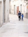 View of two young boys holding hands on a street