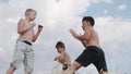 A view of two boys, figting on a training outdoors Martial Arts. Kickboxing.