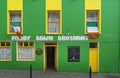 View of a typical Irish pub with a green and yellow facade.