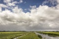 View on typical scenic Dutch landscape in het Groene Hart of the Netherlands with heavy clouds in the blue sky, lots of grassland, Royalty Free Stock Photo