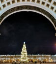 View from under the arch of the General Staff building to the Christmas fir tree on Palace Square, decorated in a retro style with Royalty Free Stock Photo