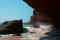 View under red sandstone stone arch in Legzira Beach. Rugged coastline in Tiznit Province of Morocco, Africa. Atlantic Ocean waves Royalty Free Stock Photo