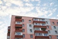 View from underneath on colorful pink apartment building in front of blue sky with clouds. City dwelling. Urban architecture Royalty Free Stock Photo