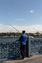 View of unrecognizable fisherman on Galata bridge in Istanbul. The image reflects lifestyle and culture of local people