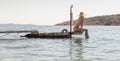 View of unrecognizable woman wearing big summer sun hat tanning topless and relaxing on old wooden pier in remote calm Royalty Free Stock Photo