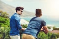 The view up here is amazing. Rearview shot of two handsome young men having drinks and relaxing outdoors while on Royalty Free Stock Photo