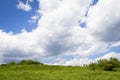 View up a hill with vast blue sky and large clouds, creative copy space opportunity Royalty Free Stock Photo