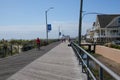 View up the long wooden boardwalk with a man riding his bike in this coastal resort town